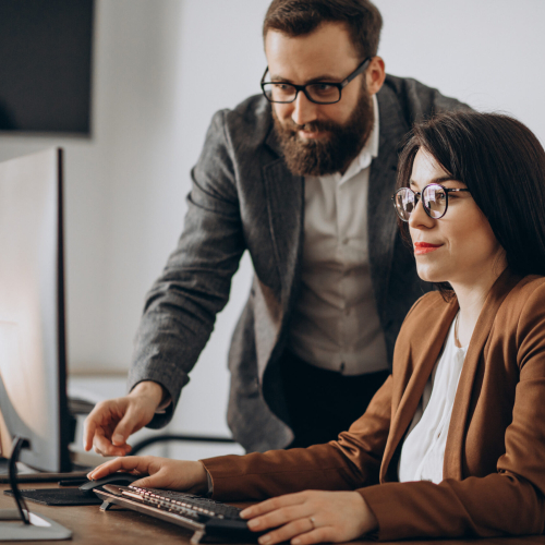 Two business partners working together in office on computer